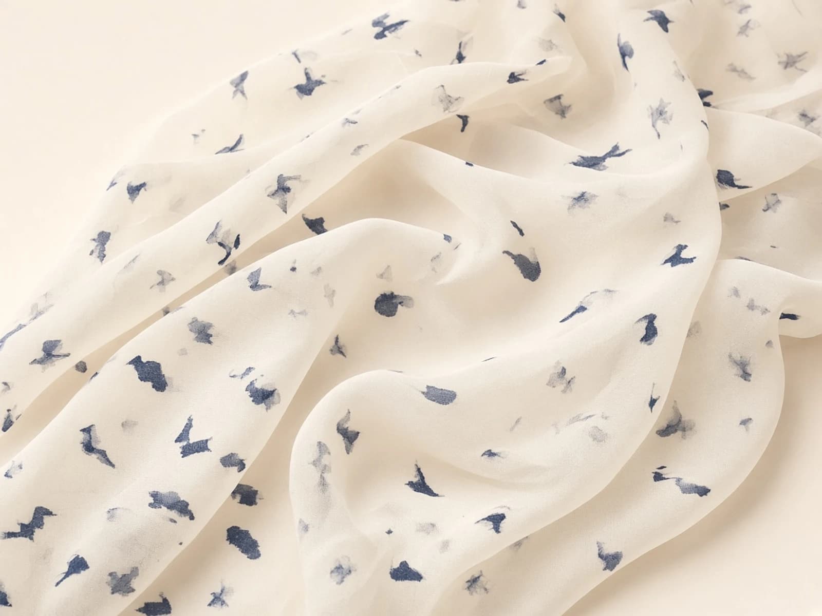 Printed chiffon with a small navy abstract pattern and sheer drape