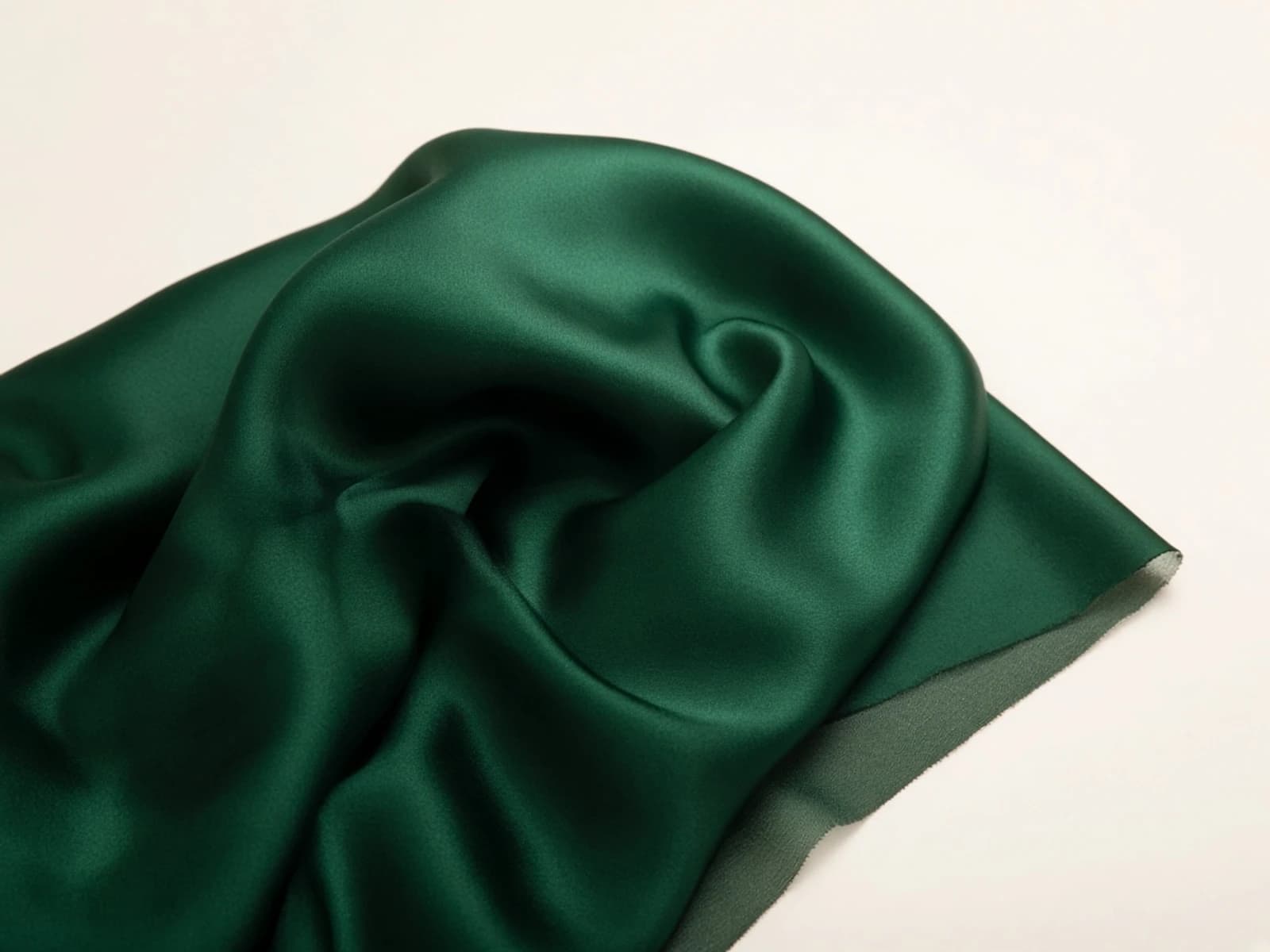 Emerald silk charmeuse with liquid drape and natural satin sheen